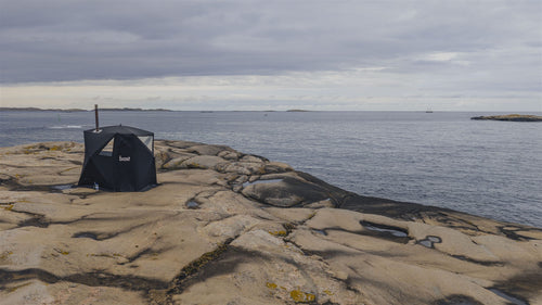 Bastutält vid havet med skorsten och ventilationsöppningar synliga